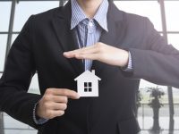 man-in-a-suit-holding-a-small-house