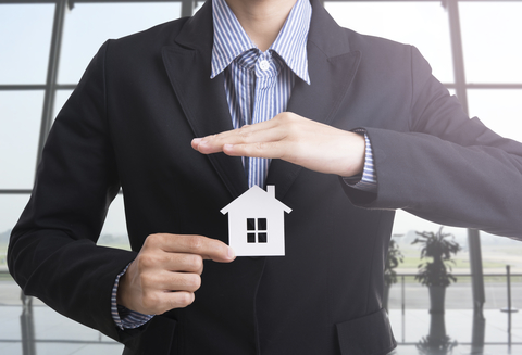 man-in-a-suit-holding-a-small-house