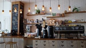 Cafe counter with espresso machine and barista preparing drinks