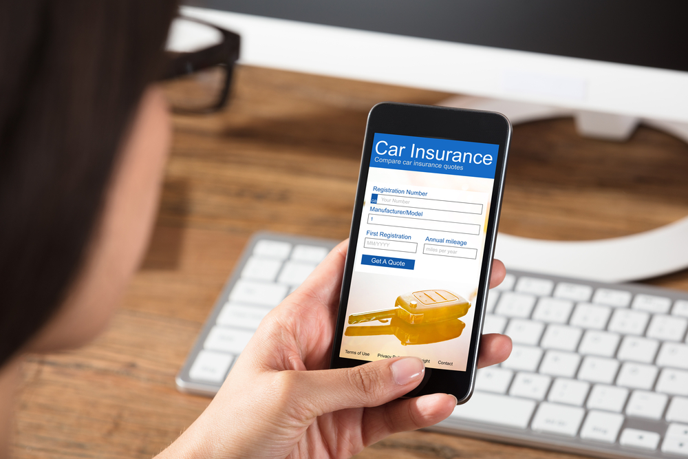 Woman Filling Online Car Insurance Form On Cell Phone