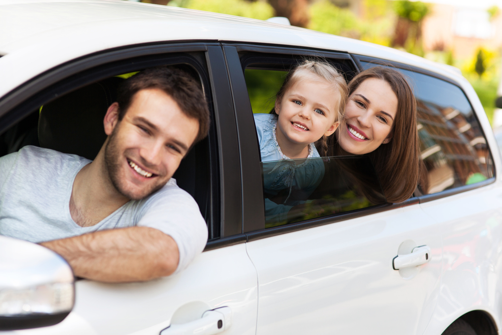 Family sitting in the car looking out windows