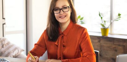 insurance agent sits at desk and smiles at camera