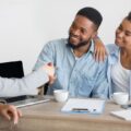 young couple shakes hands with insurance broker