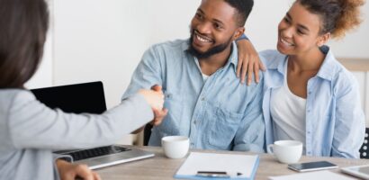 young couple shakes hands with insurance broker