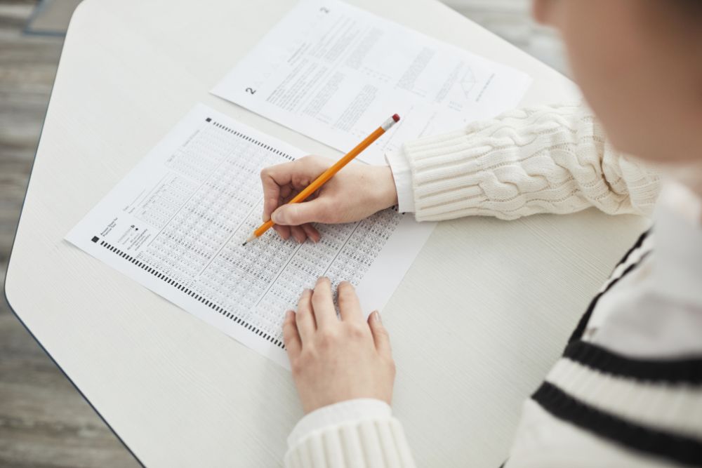 woman sits at desk and takes test