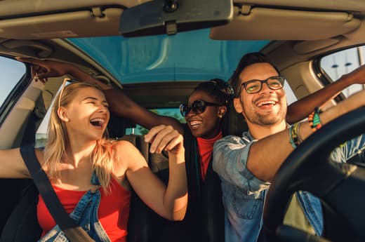 Friends laughing together while driving in a car