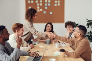 Group of people meeting at a natural wood boardroom table