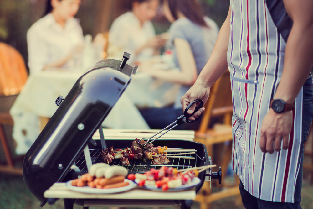 man barbecuing on a hot summer day