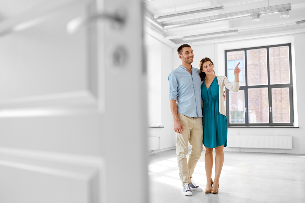 Young couple looks around an empty home interior