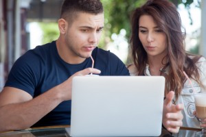 Couple comparing insurance rates on a laptop
