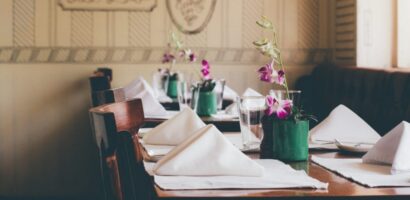 purplue-flowers-and-napkins-sitting-on-a-wooden-restuant-table