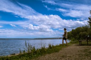 Man fishing on the shore of Pigeon Lake in Leduc County, Alberta