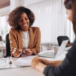 Two people meeting at a desk discussing car insurnace