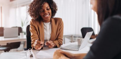 Two people meeting at a desk discussing car insurnace