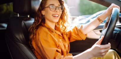 Woman smiling while driving car in daylight