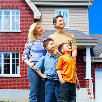Happy family looking up in front of a house